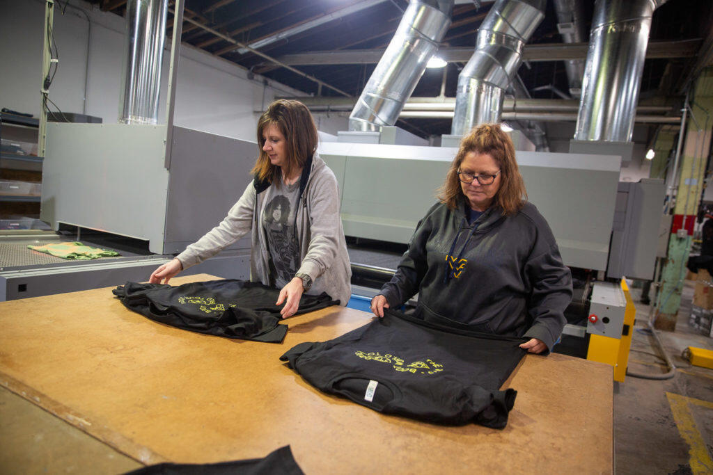 Two women organizing t-shirts