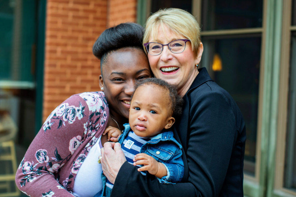 Essence and her mentor, Carrie, hug Essence's baby