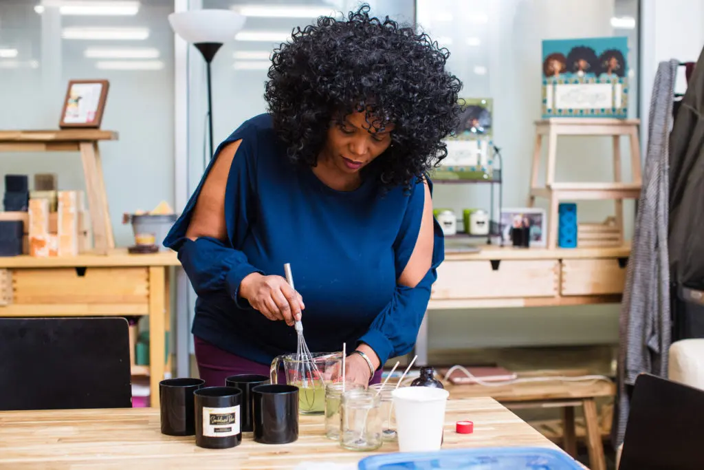 Kimberly mixes candle wax with with a whisk
