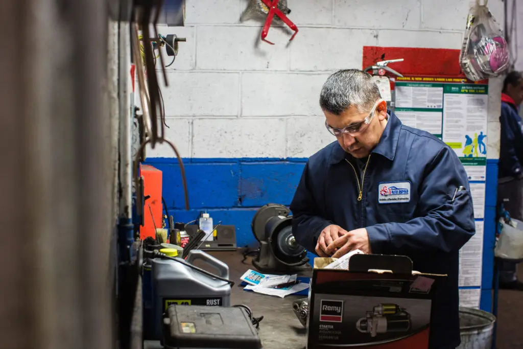 Jose opening a box with a car part inside