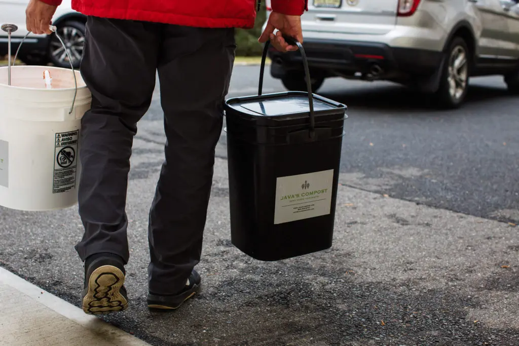 A man carrying buckets to a car