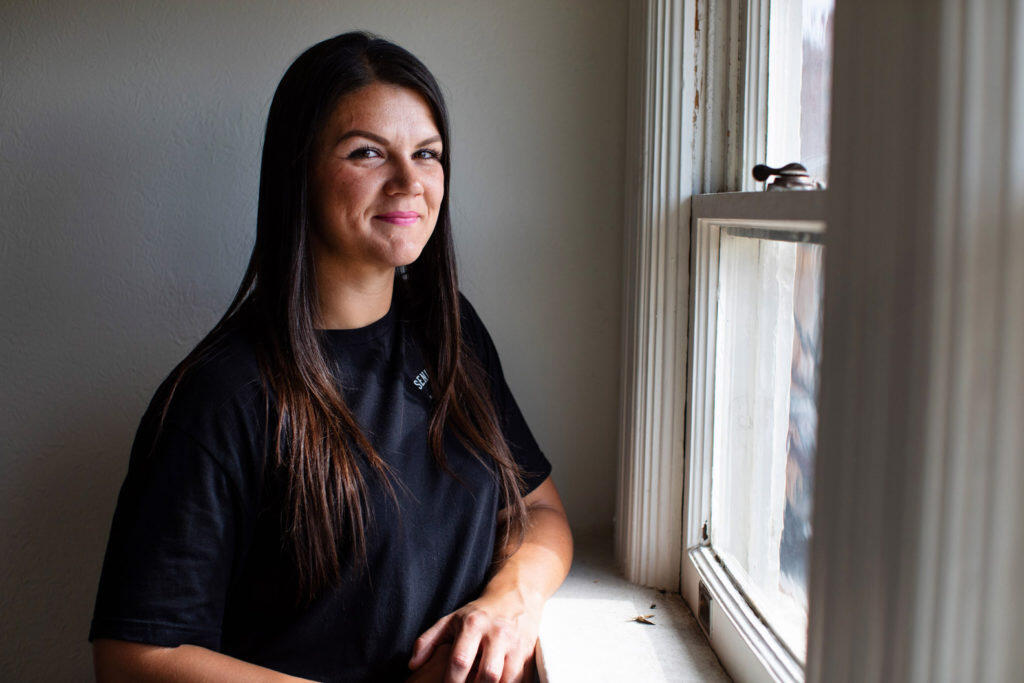Ashlee Unden smiling next to a window