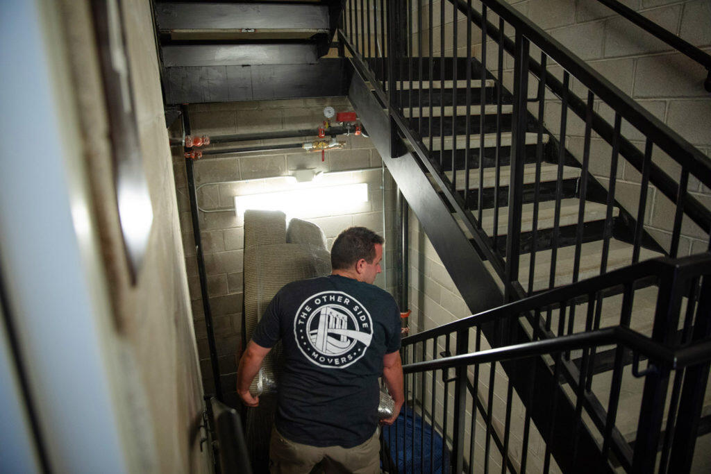 Movers carrying a couch down stairs