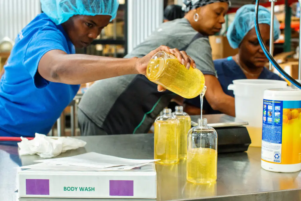 A woman hand pour soap from one bottle to another