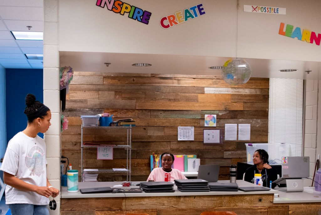 The Forest School staff member walks past two women at the reception desk
