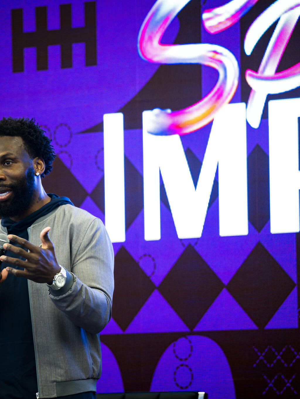 Man speaking on stage at an event.