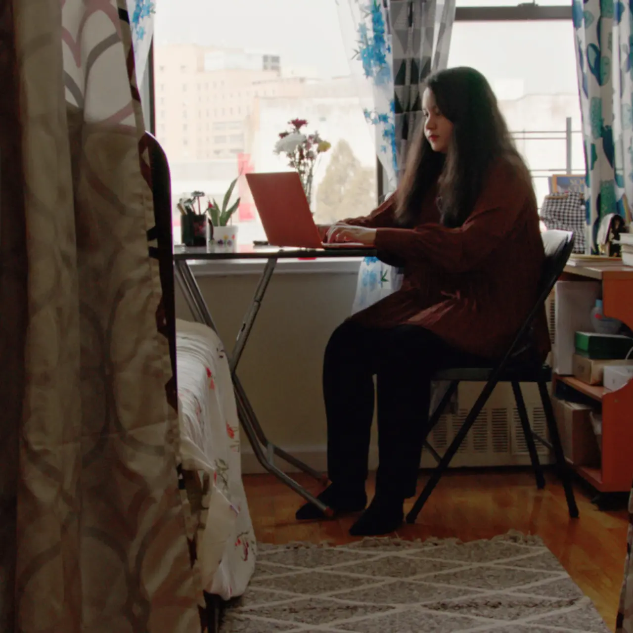 Person sitting while using a laptop.